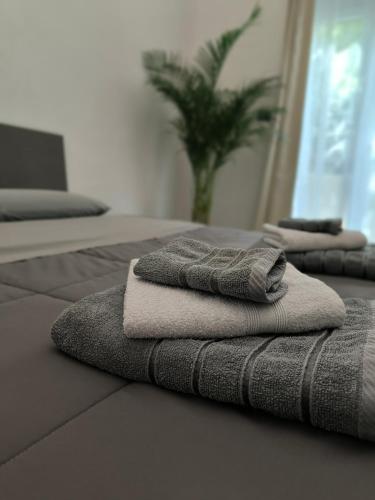 three stacks of towels sitting on top of a bed at Oasi urbana in Turin
