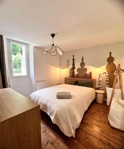 a bedroom with a large white bed with a chandelier at Nid d argile - appartement neuf - 650m des Thermes - 1er étage in Salins-les-Bains