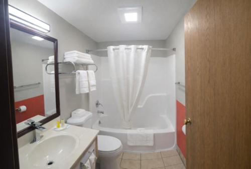 a bathroom with a tub and a toilet and a sink at Super 8 by Wyndham Lewiston in Lewiston