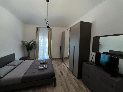 a bedroom with a bed and a flat screen tv at Oasi urbana in Turin