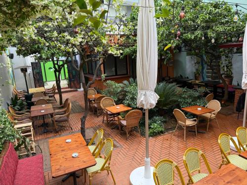 an outdoor patio with tables and chairs and an umbrella at SMALL Boutique & Garden in Tirana