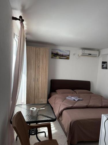a small bedroom with a bed and a table at Apartments Sole1 in Sutomore