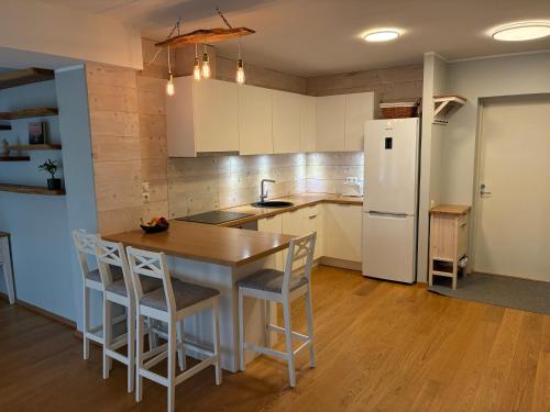a kitchen with a table and a white refrigerator at Viimsi Apartment in Haabneeme