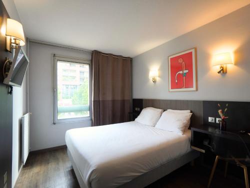 a hotel room with a bed and a window at Hotel Gascogne in Toulouse