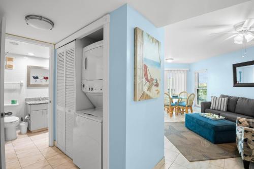 a living room with a couch and a refrigerator at Gulf Strand Resort by Travel Resort Services in St. Pete Beach