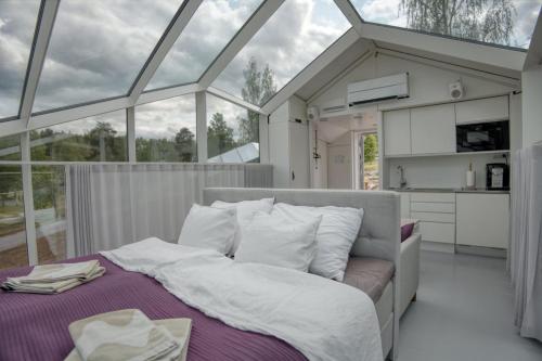 a bedroom with a bed in a room with windows at Lunar Igloos - Lumi in Karkku