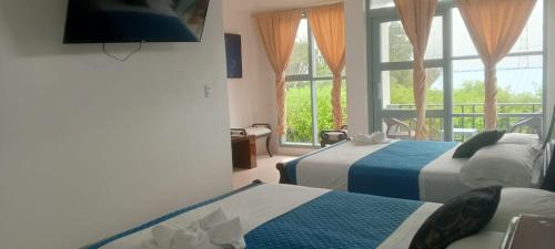 a hotel room with two beds and a window at Flightless Cormorant in Puerto Ayora