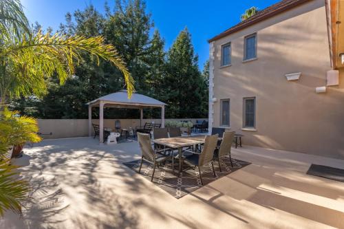 a patio with a table and chairs and a gazebo at Bella Villa Messina in Healdsburg