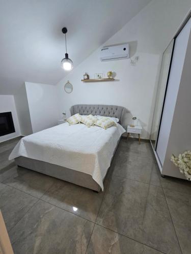 ein weißes Schlafzimmer mit Bett und Fernseher in der Unterkunft הסוויטה בטיילת in Aschdod