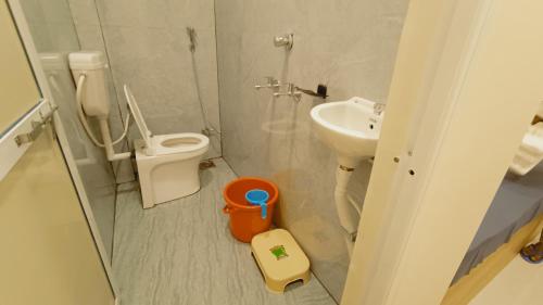 a small bathroom with a toilet and a sink at Hotel Mahakal Ujjain Prime in Ujjain