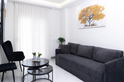 a living room with a black couch and a table at Agias Sofias Luxury Apartments in Thessaloniki