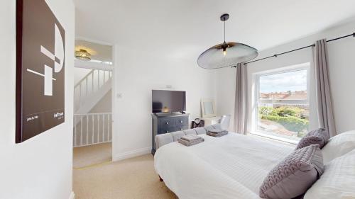 a bedroom with a bed and a large window at Sheringham Luxury, Cinema, Hot Tub & Beach in Sheringham