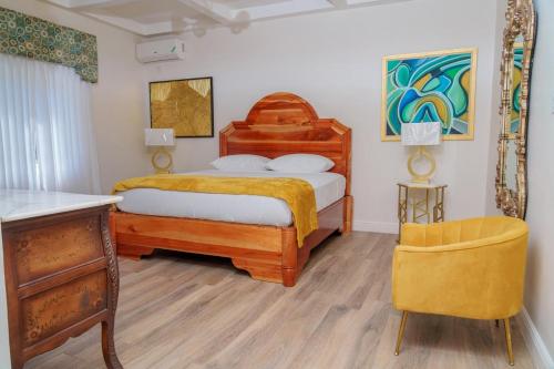 a bedroom with a wooden bed and a chair at Royale Jazz Hotel in Kingston