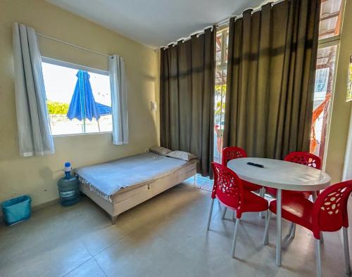 a bedroom with a bed and a table and chairs at Flats Praia de Gravatá in São José da Coroa Grande