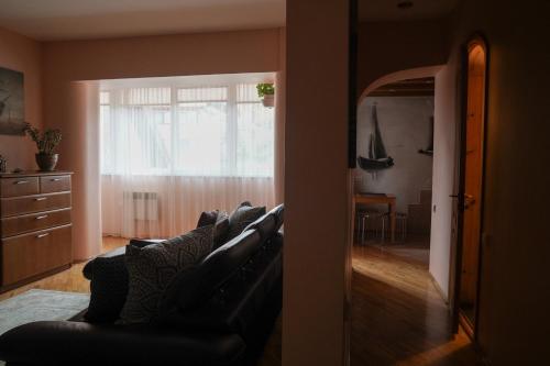 a living room with a leather couch and a dining room at Nida Center Studio Apartment in Neringa
