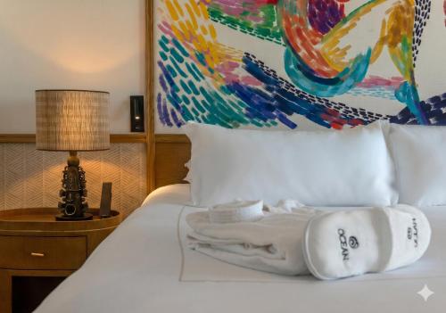 a hotel room with a white bed with a painting at Ocean Allure Costa Mujeres - Adults Only - All Inclusive in Costa Mujeres