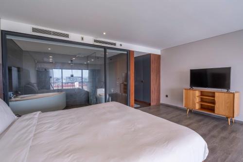 a bedroom with a large white bed and a television at Luxury Duplex & Apartment Pentstudio - Tay Ho Hanoi in Hanoi