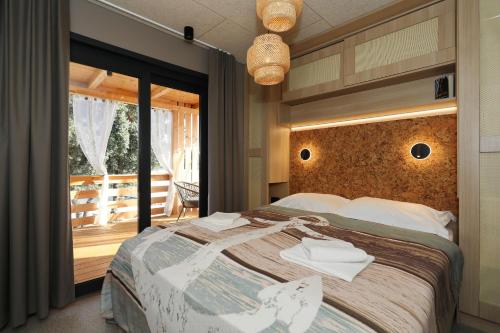 a bedroom with a large bed and a balcony at Strandhaus Ahoi 17, Terrasse mit Meerblick, Privatstrand, 2 Badezimmer in Drage