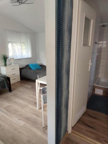 a room with a bedroom and a bed and a table at Morska Fala in Sarbinowo