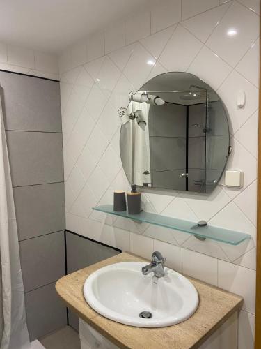 a bathroom with a sink and a mirror at Caparica Sol&Mar Apartment in Costa da Caparica