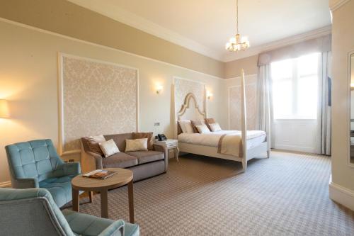 ein Wohnzimmer mit einem Bett und einer Couch in der Unterkunft Wroxall Abbey Hotel & Estate in Wroxall
