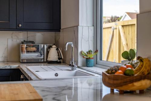 a kitchen with a sink and a bowl of fruit at 11 Dune View in Braunton