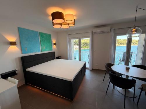 a bedroom with a bed and a table and chairs at Apartman Blaga in Povlja