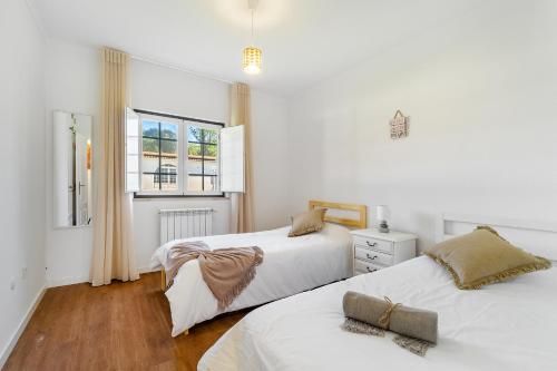 a bedroom with two beds and a window at Quinta do Outeiro by Soulplaces in Almargem
