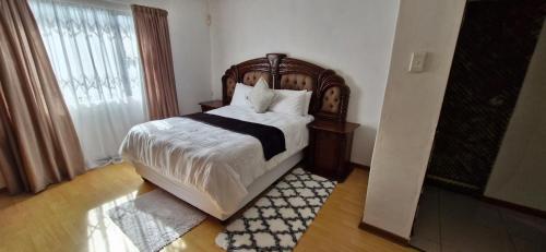 a bedroom with a large bed with a wooden headboard at Simlily Place in East London