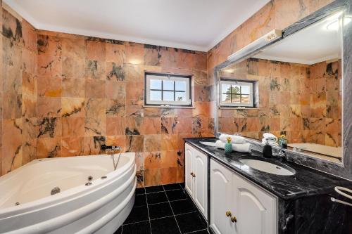 a bathroom with a tub and a sink at Quinta do Outeiro by Soulplaces in Almargem