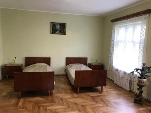 a bedroom with two beds and a window at Сколе Серце Карпат in Skole