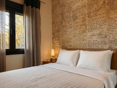 a bedroom with a large bed and a wall with writing at SpitiAyia in Ayiá