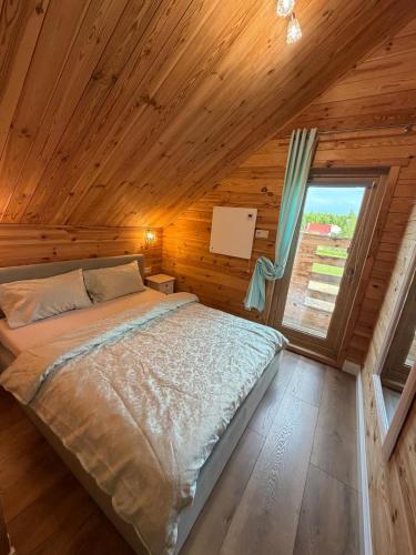a bed in a room with a wooden ceiling at Luna House in Łoje