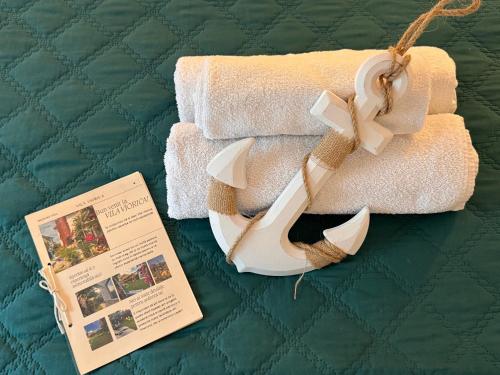 a pair of towels and a pamphlet on a bed at Vila Viorica in Mamaia Sat/Năvodari