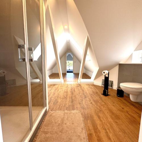 an attic bathroom with a toilet and a shower at Käpitänshaus zum Plümper in Ahrenshoop