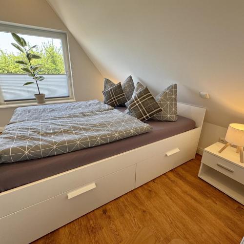 a bedroom with a bed with a window at Käpitänshaus zum Plümper in Ahrenshoop