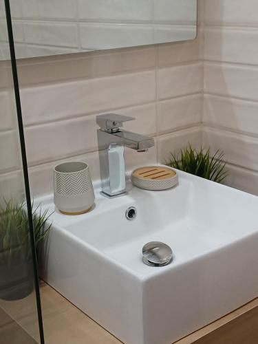 a white bathroom sink with a faucet on it at Studio ONE in Kiten