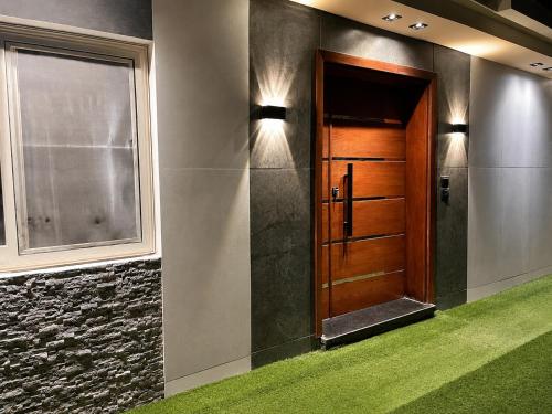 a hallway with a wooden door and a window at Leila Home Garden - Maamourah Beach in Alexandria