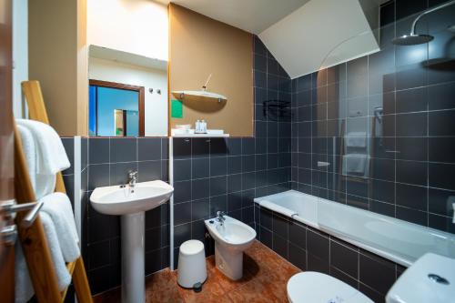 a bathroom with a sink and a toilet and a tub at Hotel A. G. Porcillan in Ribadeo