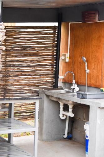 a kitchen with a sink and a wooden wall at Kwelanga River Lodge in Vioolsdrif