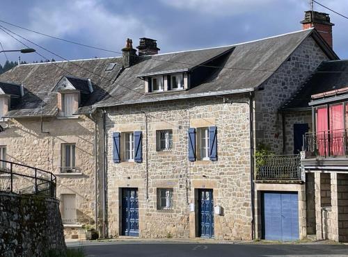a large stone house with a gray roof at Vue sur la Vezere in Treignac