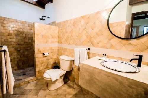 a bathroom with a sink and a toilet and a mirror at Posada Casa Play Los Roques in El Roque