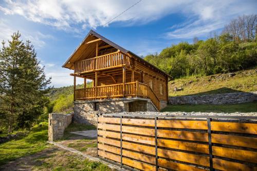 a wooden cabin with a balcony on a hill at Brvnara Vasić - Stara planina in Pirot