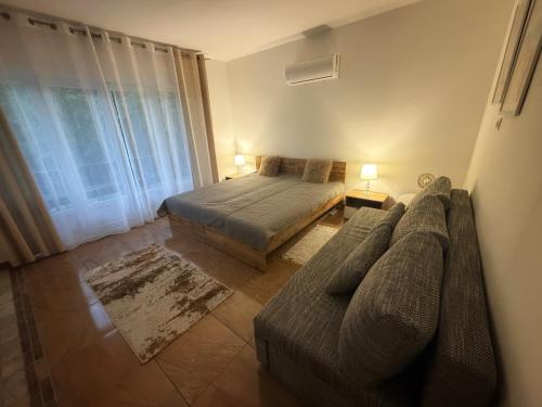 a bedroom with a bed and a couch at Fifteenapartman in Balatonföldvár