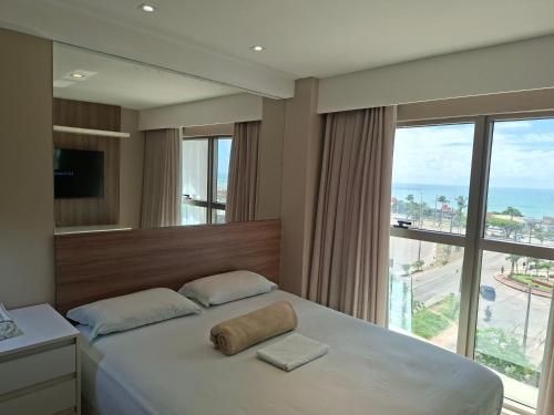 a bedroom with a large bed with a large window at Brisa Calma Premium Flat - PontaNegra in Natal