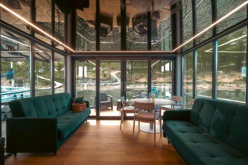 a room with two green couches and a table at Solina Houseboat Polańczyk in Polańczyk