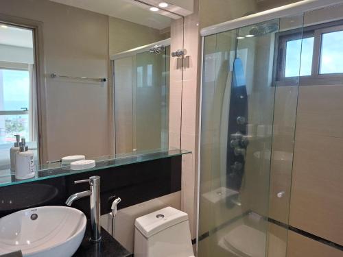 a bathroom with a shower and a toilet and a sink at Brisa Calma Premium Flat - PontaNegra in Natal