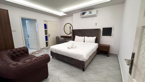 a bedroom with a bed and a couch and a chair at Family Beach Villas in Salalah