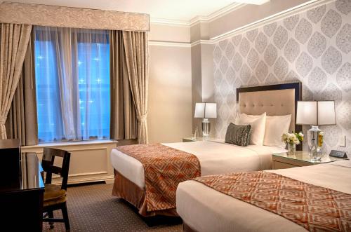 a hotel room with two beds and a window at Warwick New York in New York
