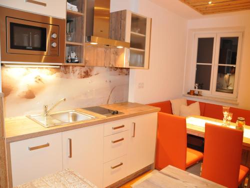 a kitchen with a sink and a living room at Romantikappartement Petz**** in Donnersbachwald